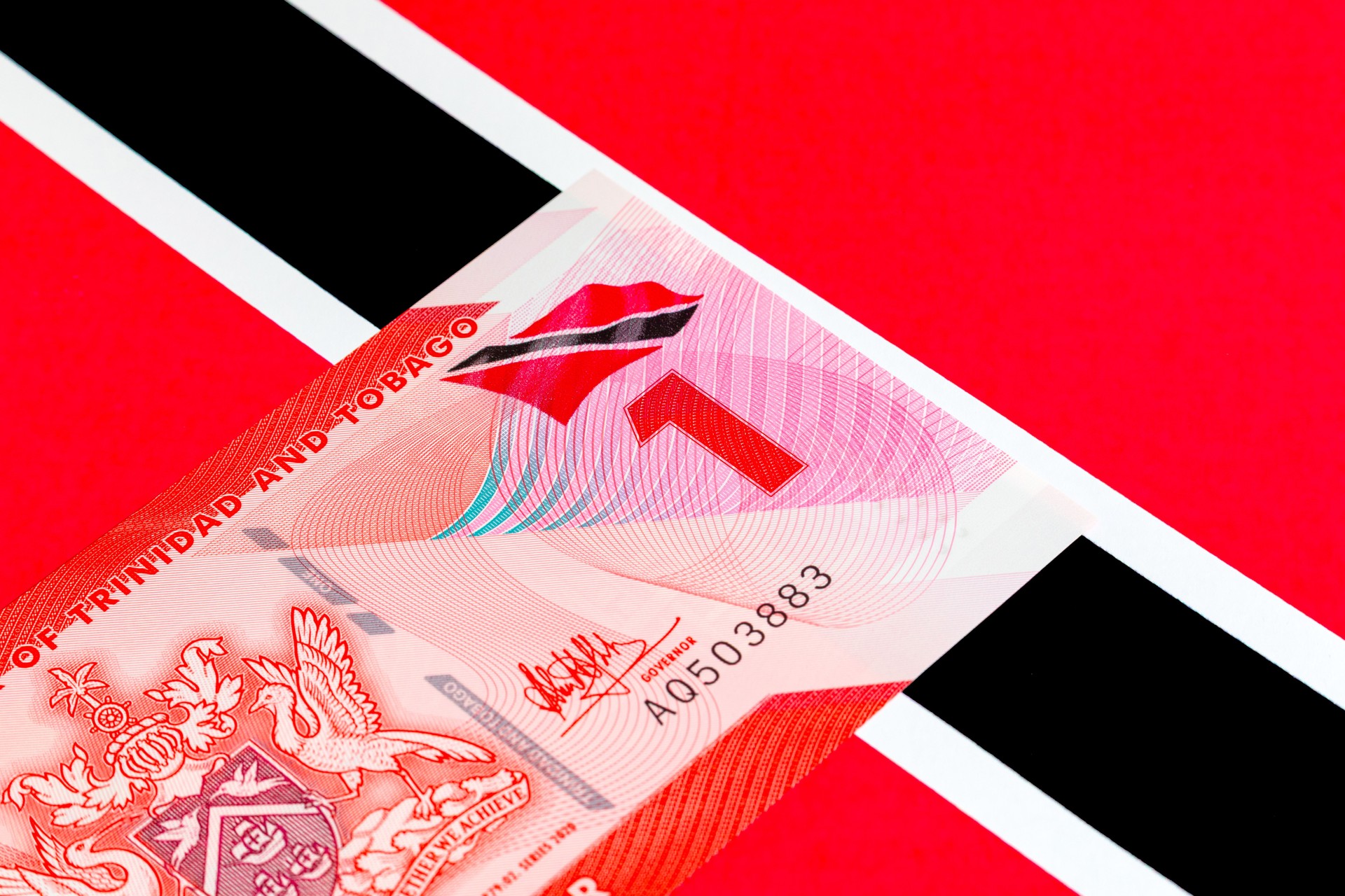 1 dollar Trinidad and Tobago on the background of the country's national flag. Plastic money